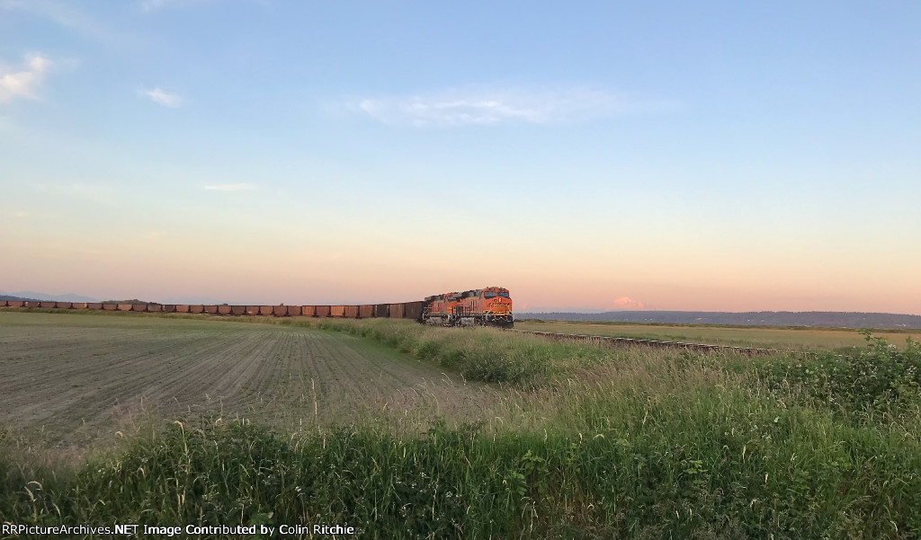 E/B BNSF 7126/7712 heading for the Mud Bay crossing at sunset....Mt. Baker in the background.